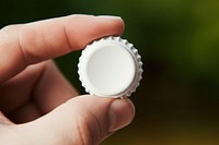 Beer bottle cap hand finger white. AI generated Image by rawpixel.