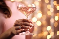 Woman holding a pink champagne glass photo. .