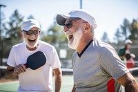 Playing pickleball laughing glasses sports. 