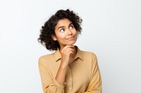 Person with curly hair in a thoughtful pose, wearing a beige shirt, looking upward with a slight smile, against a plain background.