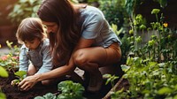 A photo of mother teaching her child how to dig in the backyard garden.  