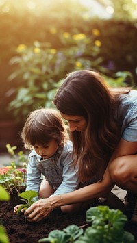 A photo of mother teaching her child how to dig in the backyard garden.  