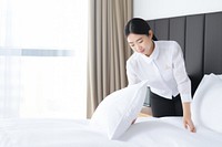 Hotel staff making bed. 