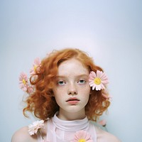 Young woman posing for a picture with a flower hanging by the ear