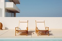 White deckchairs furniture outdoors architecture. 