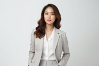 Confident woman in a gray suit, professional attire. Businesswoman with long hair, gray suit, and white shirt. Asian woman, professional look, gray suit.