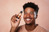 Smiling man cosmetics bottle face. 