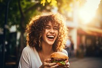 Eating burger laughing outdoors adult. 