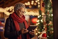 Woman using tablet christmas architecture illuminated. AI generated Image by rawpixel.