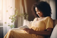 Black woman pregnant reading sitting adult. 