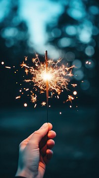 Aesthetic sparkler mobile wallpaper fireworks sparks hand. AI generated Image by rawpixel.