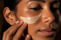 Native american indigenous woman applying skincare cream cosmetics adult face