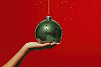 Christmas ball hanging green hand. AI generated Image by rawpixel.
