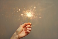 Hand holding sparkler finger sparks illuminated. AI generated Image by rawpixel.