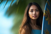 A young Indonesian woman holding a surfboard portrait outdoors nature. AI generated Image by rawpixel.