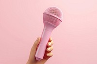 Hand holding a microphone performance technology appliance. AI generated Image by rawpixel.