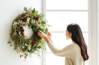 Adjust dried christmas wreath adult woman wall. AI generated Image by rawpixel.