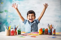 Little girl sitting at a table with stationery and paint child joy creativity. AI generated Image by rawpixel.