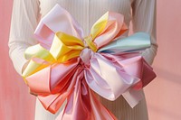 Hand holding big bow full color gift celebration creativity. AI generated Image by rawpixel.