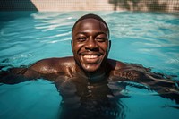 Black man swimming in a pool smiling sports smile. 