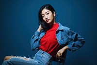 Thai woman wearing denim trend Red Stitched sitting red contemplation. AI generated Image by rawpixel.