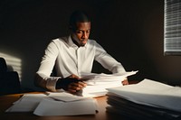 Black man Sitting at Her Desk Working on a pile of documents sitting working adult. AI generated Image by rawpixel.