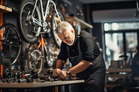 Old Technical expertise man taking care Bicycle Shop bicycle workshop vehicle. 