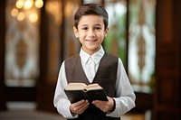 A smile student muslim boy holding book publication portrait child. AI generated Image by rawpixel.