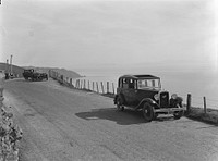 Cars on hillside road (1920s-1930s).