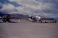 Freighter, plane ready to taxi out to airstrip for takeoff (24 March 1959) by Leslie Adkin.