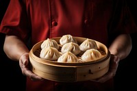 Chef holding a freshly cooked dimsum dumpling food xiaolongbao. AI generated Image by rawpixel.