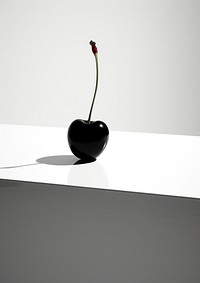 A cherry on a white table plant black freshness. AI generated Image by rawpixel.