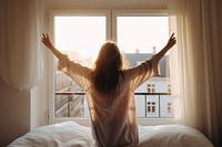 Woman wakes up window bed furniture. 