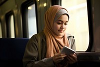 Indonesian student in the train adult technology headscarf. AI generated Image by rawpixel.