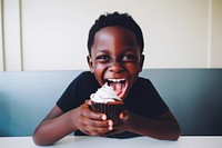 Black boy eating cupcake portrait dessert smiling. AI generated Image by rawpixel.