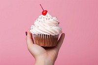 Hand holding a cupcake dessert cream food. AI generated Image by rawpixel.