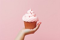 Hand holding a cupcake dessert cream food. AI generated Image by rawpixel.