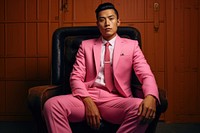 Vietnamese man sitting adult pink. AI generated Image by rawpixel.