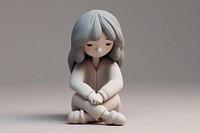 Young depressed female character sitting on the floor and holding their knees figurine toy representation. AI generated Image by rawpixel.