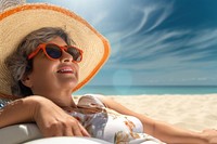 Hispanic cuban middle age woman take a sunbath on beach sunbathing glasses summer. AI generated Image by rawpixel.