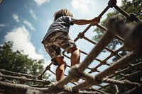 A child climbs up an alpine grid playground outdoors day. AI generated Image by rawpixel.