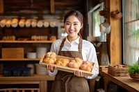 Asian bakery owner holding tray of bread food chef entrepreneur. AI generated Image by rawpixel.