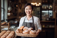 Asian bakery owner holding tray of bread adult food entrepreneur. 