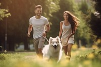Young couple run and play with dog running mammal animal. 