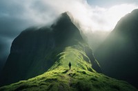 Man walking on the grassy mountain top landscape adventure outdoors. 