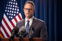 Middle age male American official talking in the press conference microphone glasses adult. AI generated Image by rawpixel.