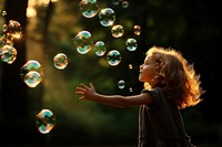 Floating bubbles portrait outdoors child. 