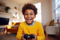 A american african boy in yellow sweater holding a Controller portrait smile child. AI generated Image by rawpixel.