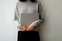 A woman with a black jumper holding a gray blank folder sweater sleeve accessories. 