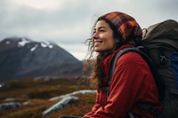 A Latina Mexican female backpacker sitting and gazing happily at the sky in Alaska nature adventure outdoors. 